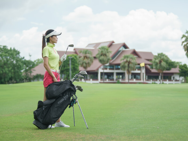 ゴルフバッグを持つ女性